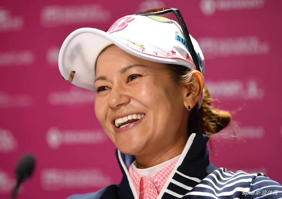 田仁智俏皮地与印有自己肖像的赛事宣传板合影,手指头像展现卫冕冠军的自信与幽默