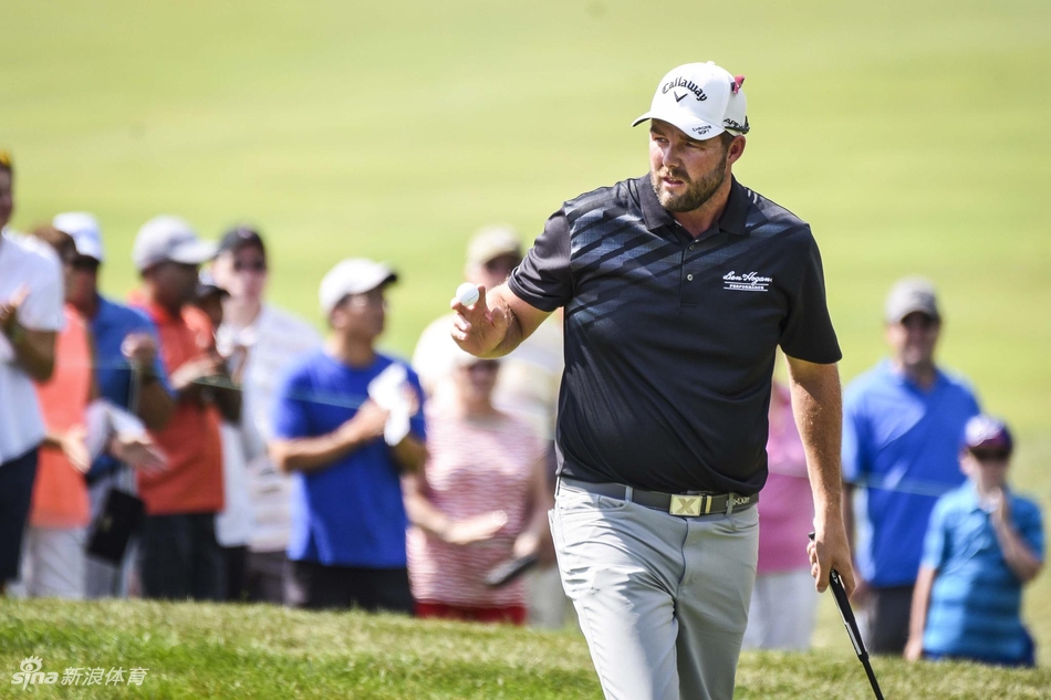 里奇·福勒在果岭上专注推杆，橙色的帽子在绿茵场上格外醒目