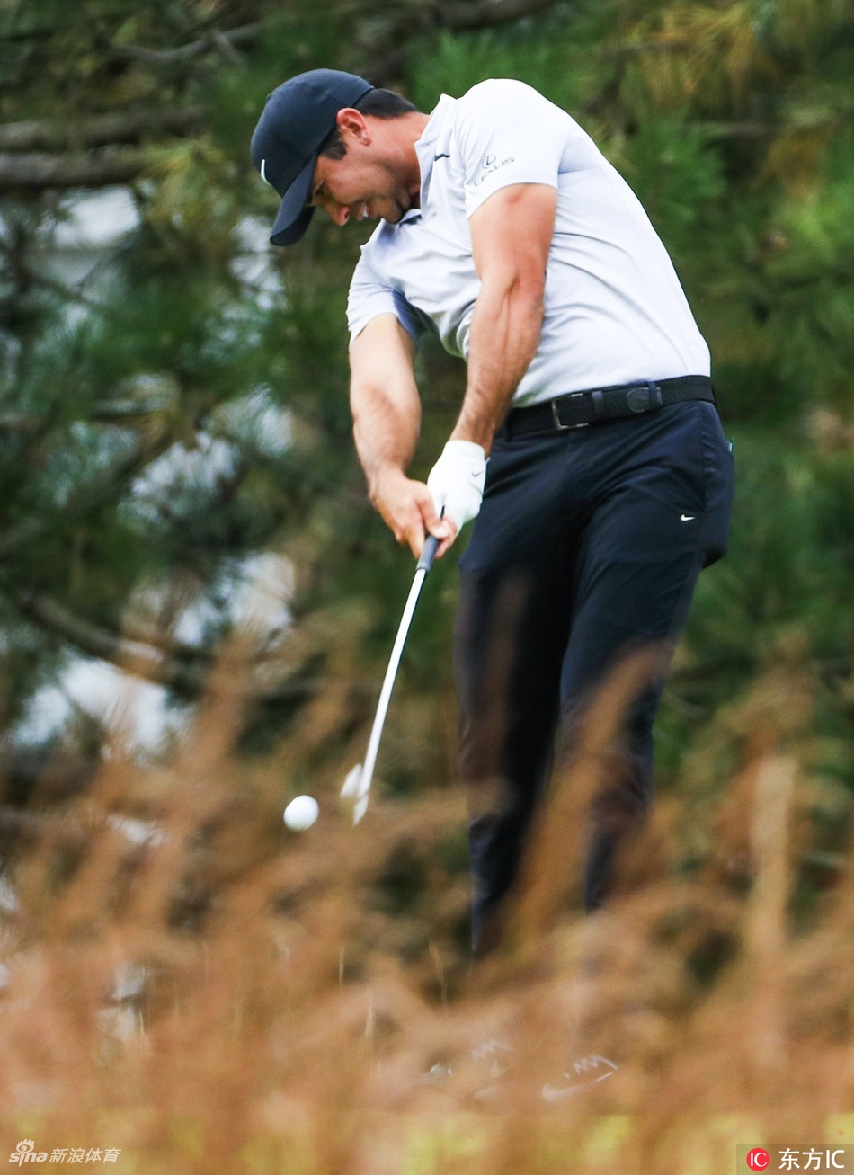 利什曼高举冠军奖杯向观众致意，阳光洒在银光闪闪的奖杯上