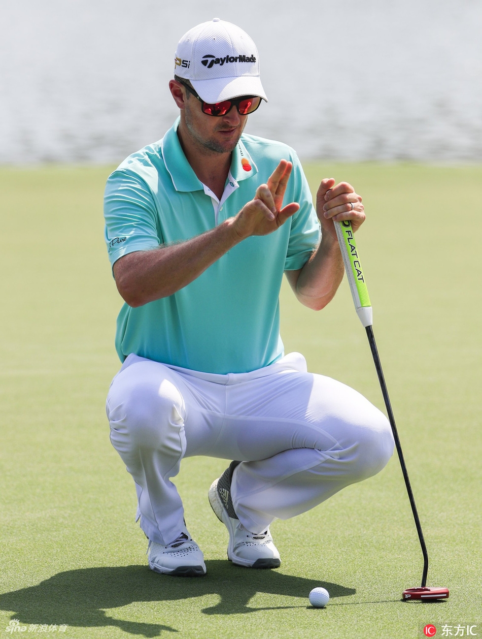 球员与球童在球道上并肩行走讨论策略，夕阳将他们的身影拉长在东湖球场的金色草地上