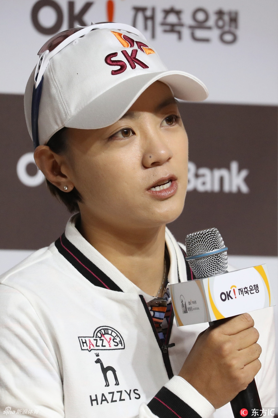 崔萝莲手持专属球童背心，笑容甜美，气质清新动人