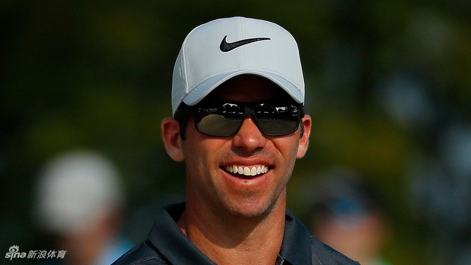 达斯汀·约翰逊在发球台上，目光如炬地注视着远方落球区，充满力量的挥杆预备姿势蓄势待发。