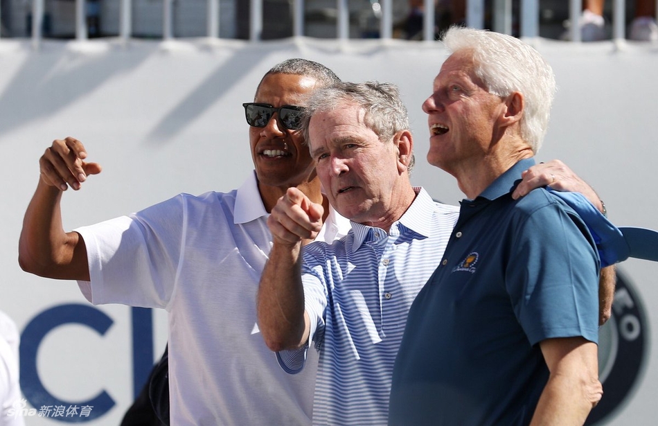 巴拉克·奥巴马正面向观众席挥手致意，脸上洋溢着亲切的笑容，背景中可见出席开幕式的各界人士。