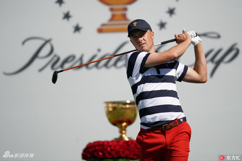 贾斯汀·托马斯在发球台上全力挥杆，身体姿态充满力量与扭转的张力，目光望向球飞出的远方。