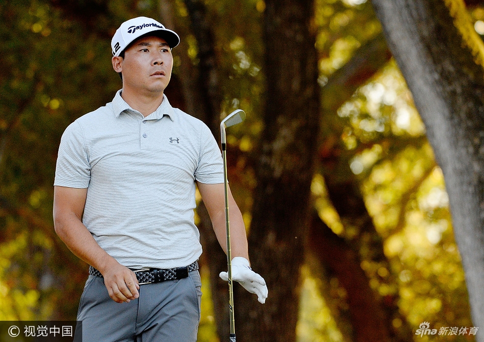 高尔夫传奇名将‘老米’在首轮比赛中沉着推杆，其经典的比赛风格与身后广阔的球场构成一幅动人画卷。