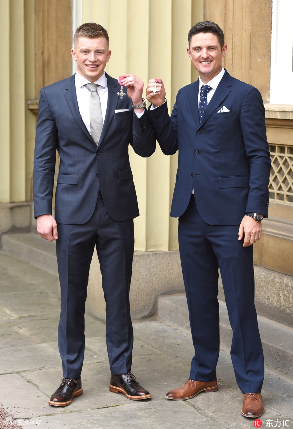 亚当·佩蒂与贾斯汀·罗斯在典礼后轻松交谈,佩蒂手势生动,似乎正在分享授勋的兴奋心情,两人之间洋溢着惺惺相惜的友好氛围。