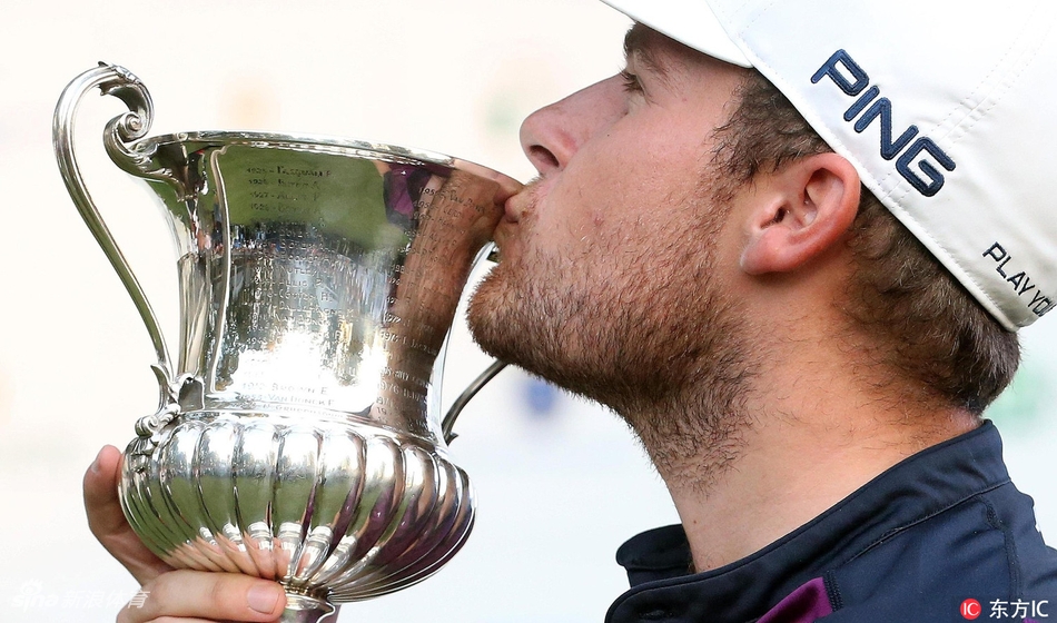 泰瑞尔·哈顿深情俯身，亲吻来之不易的冠军奖杯，眼中闪烁着胜利的泪光与纯粹的喜悦。