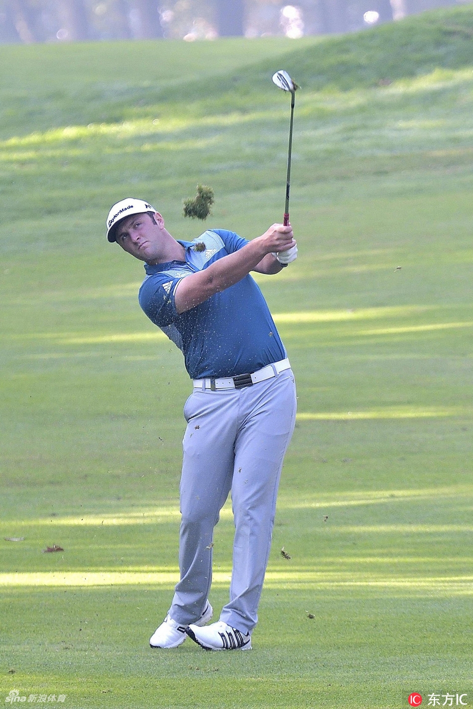 汤米·弗利特伍德在全神贯注地挥杆击球，身体姿势优雅而充满力量，小白球在阳光下划出一道完美的弧线。