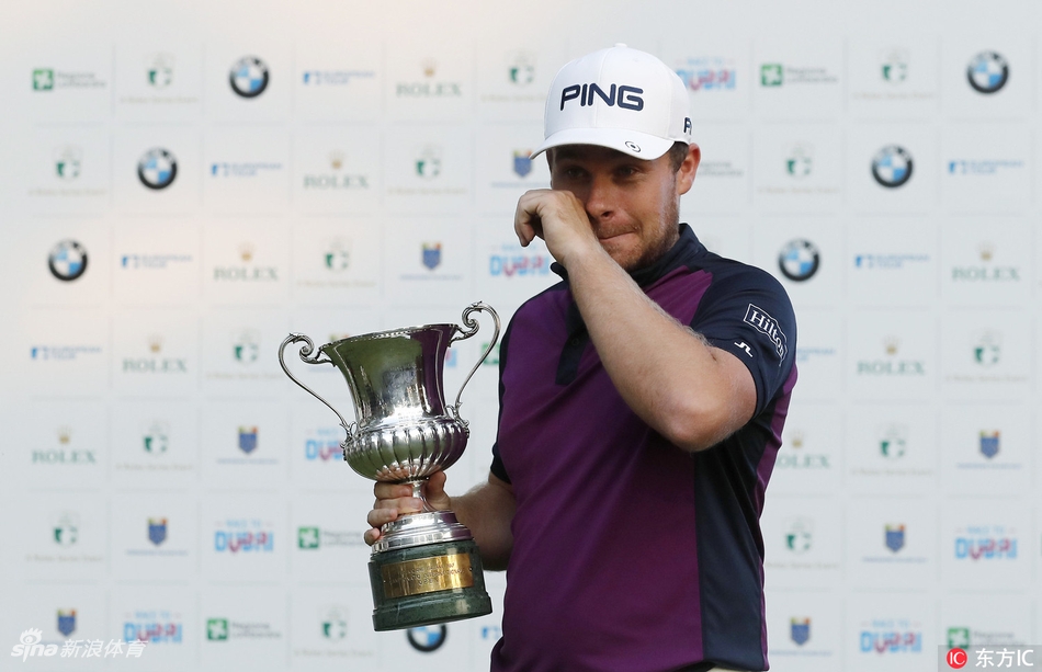 哈顿与身着鲜艳服装的赛事志愿者们开心合影，灿烂的笑容与身后的罗马古城背景构成一幅温馨画面。