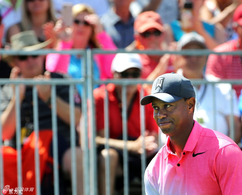 老虎伍兹向场边为他加油的观众挥手致意,脸上带着谦和的微笑,这短暂互动连接起了巨星与球迷之间的情感。