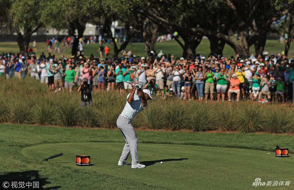 伍兹在球道中段用长铁杆进攻果岭，动作流畅而稳定，显示出其经过调整后日益可靠的击球状态。