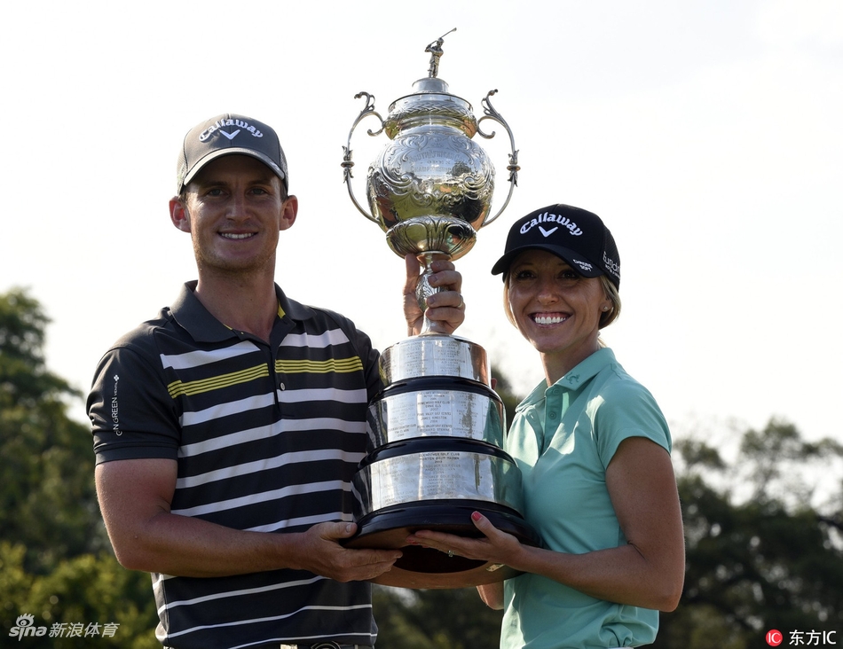 佩斯利与担任球童的妻子凯莉在比赛中并肩行走,两人认真讨论着下一杆策略。