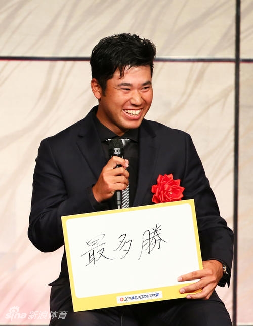 松山英树手持奖杯,目光坚定地望向远方,神情中充满了对未来的决心与自信