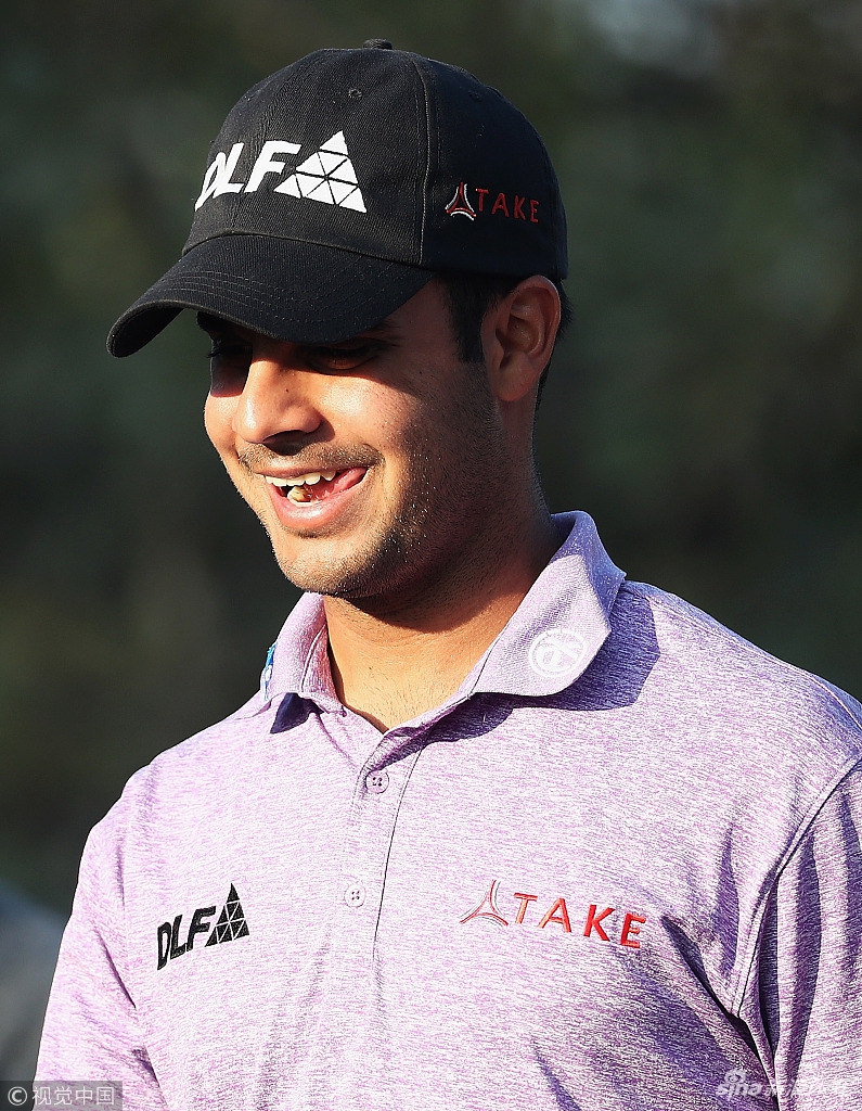 一名球手在黄昏的柔和光线下完成推杆动作，他的剪影与空旷的果岭构成一幅优美的画面，比赛已近尾声。