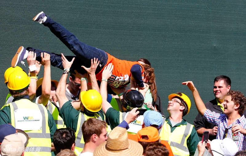 两位身着美国海军制服的军人球迷正在认真观看比赛，他们挺直的站姿与周围休闲的观众形成有趣对比，体现了赛事对军人的尊重和包容。