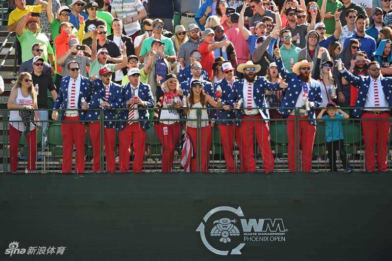 两位身着芝麻街埃尔莫和甜饼怪毛绒玩偶装的球迷正在高尔夫球场边热烈欢呼，鲜红的色彩在绿茵场上格外醒目，仿佛卡通人物闯入了现实世界。