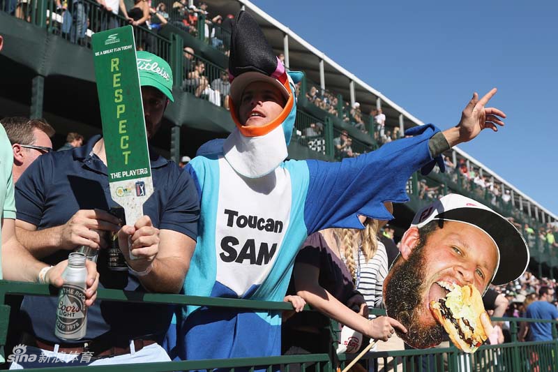 一名留着个性胡须的男性球迷身穿朋克风格皮夹克，头戴军帽，正举起右手做出摇滚手势，背景中可见其他观众的身影，展现出赛事自由奔放的氛围。