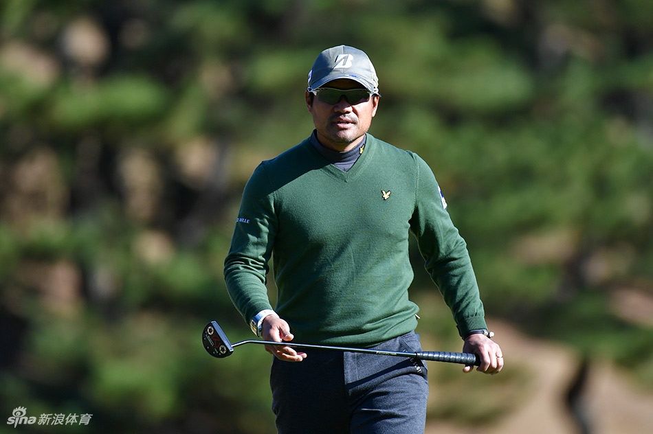 梁文冲走向下一洞发球台，步伐沉稳自信，背景是典型的日巡赛球场风景
