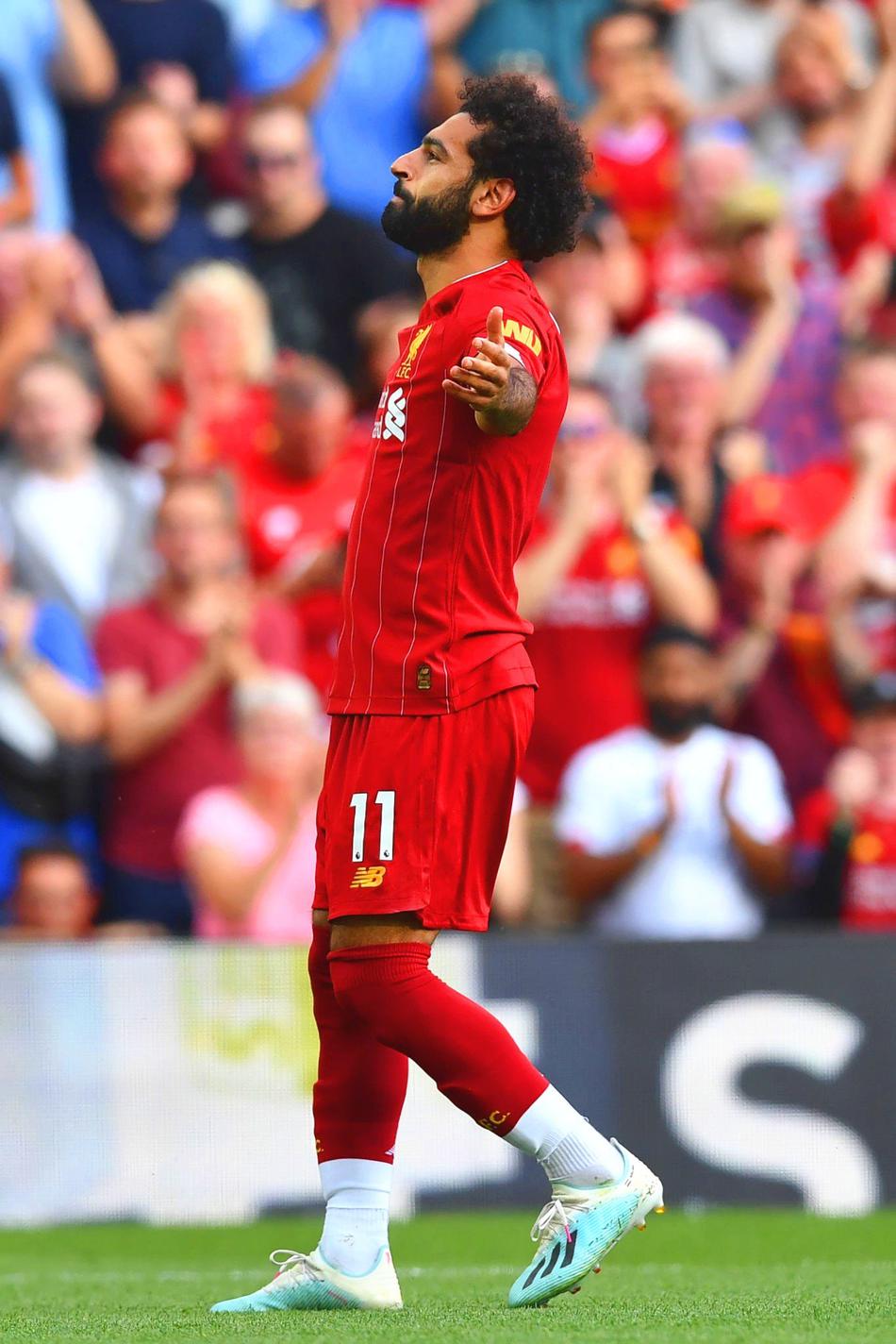 萨拉赫在攻破阿森纳球门后，激情滑跪庆祝，脸上写满了坚毅与霸气，身后的看台则是沸腾的红军球迷。