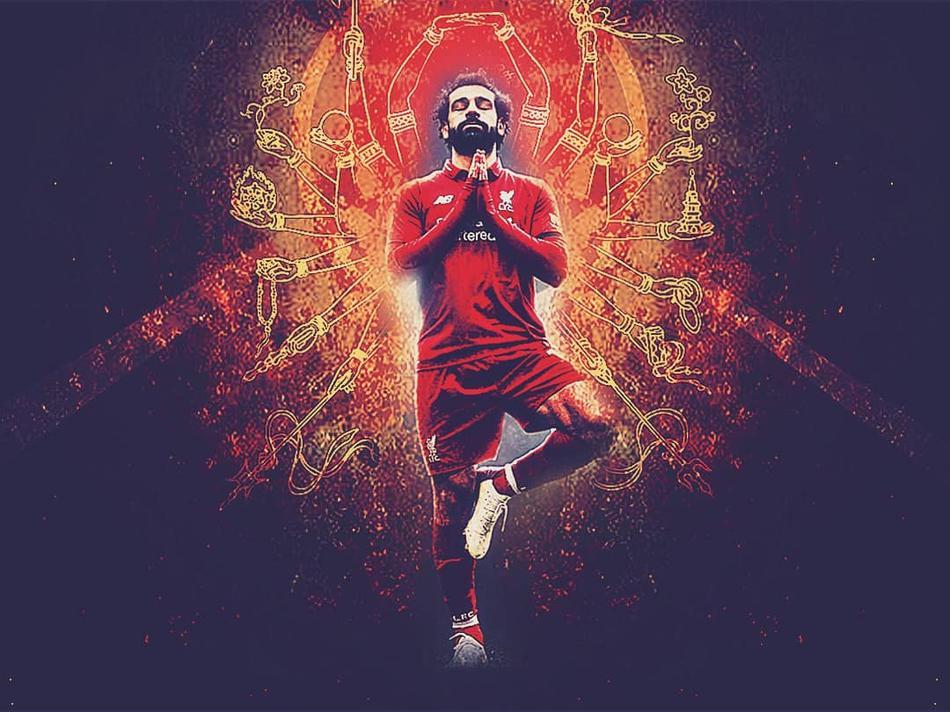 一位街头艺人将自己打扮成萨拉赫的样子，在熙攘的步行街中央做出瑜伽庆祝动作，面前摆着用于表演的帽子，这个独特的造型成功吸引了过往行人驻足拍照，成为街头一景。