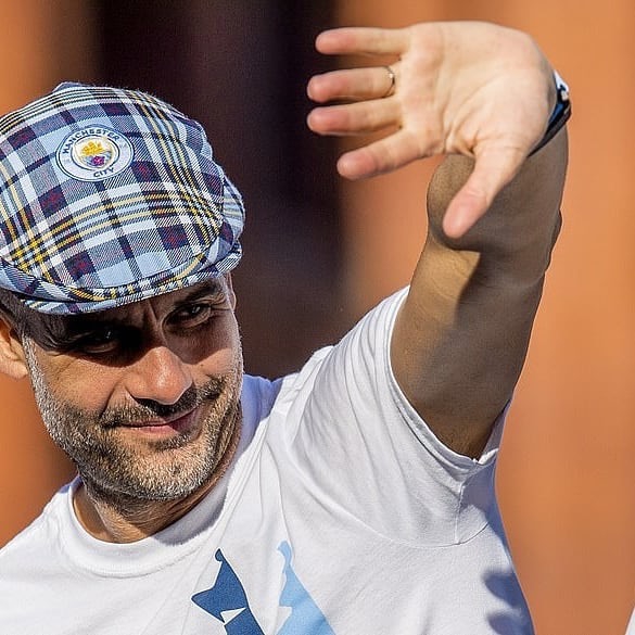 瓜迪奥拉在敞篷大巴上，双手指天，脸上洋溢着孩子般的兴奋笑容，仿佛在向整座城市宣告王者的归来。