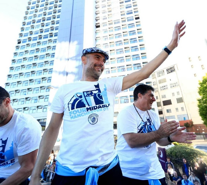 从高处俯瞰，曼城球迷组成的蓝色人海淹没了街道，旗帜飘扬，场面壮观至极，展现了这支球队身后无与伦比的强大支持。