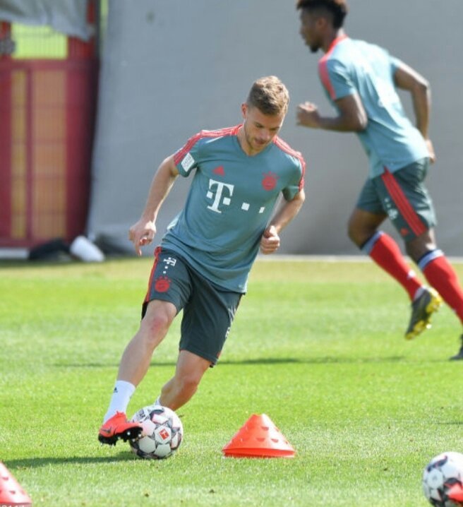 训练场全景，莱万处于画面中央焦点，周围球员和教练形成虚化背景，他的犀利眼神成为整个画面中最突出的元素。