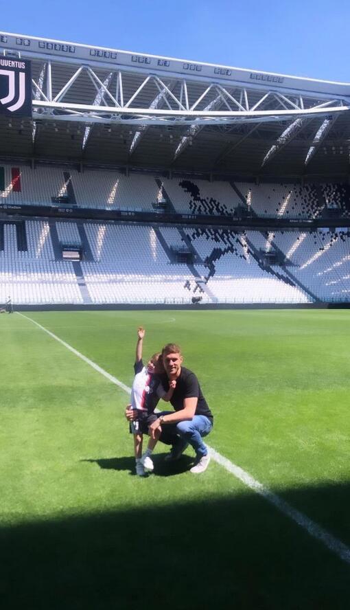 一张温馨的合影，拉姆塞与儿子额头相抵，眼神中满是宠溺。小家伙穿着尤文图斯的连体衣，父子情深在黑白背景下显得格外动人。