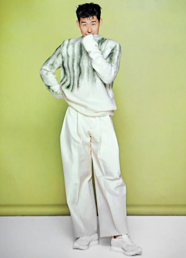 孙兴慜身着剪裁利落的深色西装，眼神深邃地凝视镜头，在冷色调光影中展现出与球场上截然不同的沉稳与贵族气质