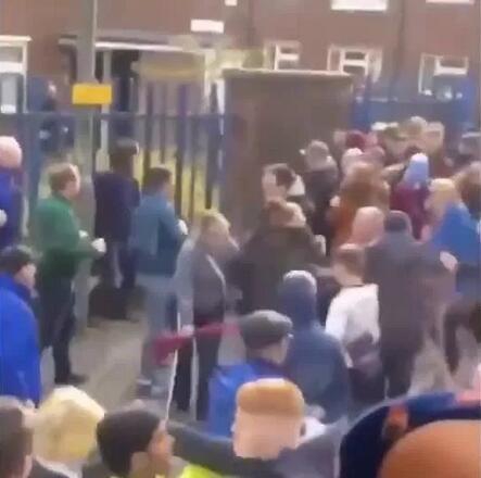 一名身穿伯恩利球衣的球迷被警察按倒在地制服，旁边是散落一地的饮料罐和碎纸屑