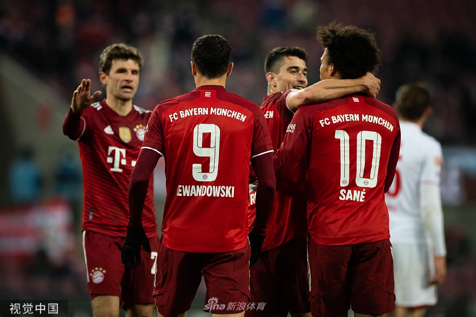 拜仁慕尼黑全队在客场更衣室内集体合影，手举比赛用球庆祝胜利，笑容洋溢在每一位球员脸上