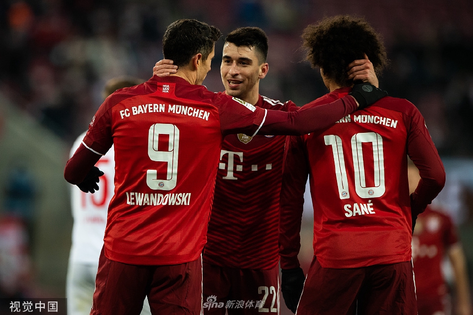 莱万多夫斯基手指向天空庆祝进球，背景中科隆门将颓然坐地，鲜明对比出进球者的辉煌与胜利者的姿态