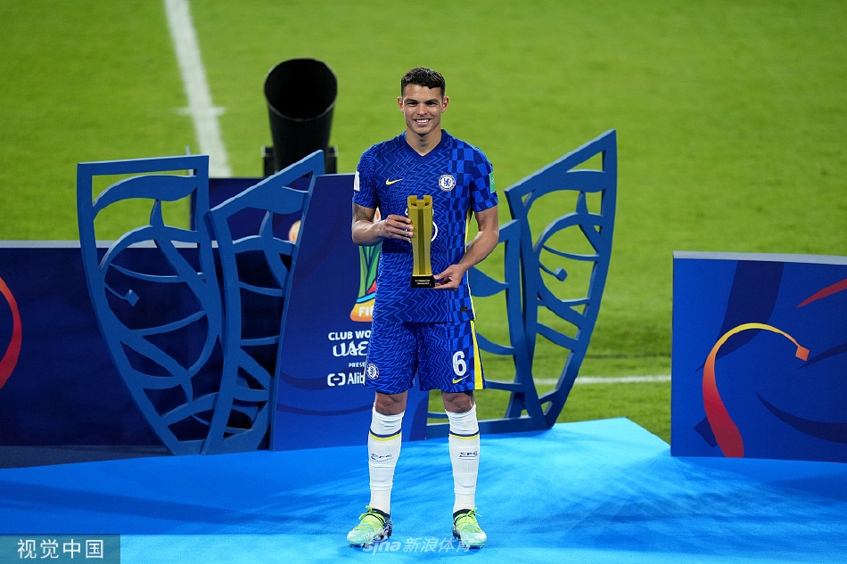 切尔西老板阿布拉莫维奇手捧世俱杯冠军奖杯，面带微笑，身后是欢呼的球员，这一刻标志着俱乐部荣誉室的最终圆满。