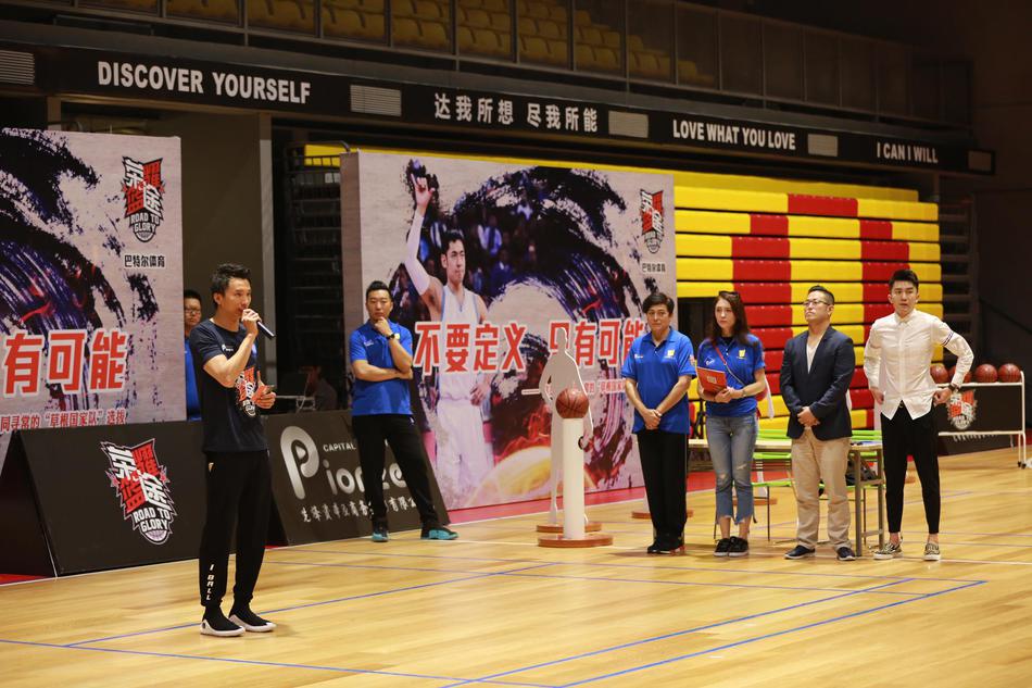 晋级十四强的队伍围成一个圈，手臂搭着彼此的肩膀，齐声怒吼庆祝，汗水在灯光下闪闪发光，背景是渐渐落下的夕阳和仍在收拾器材的工作人员。