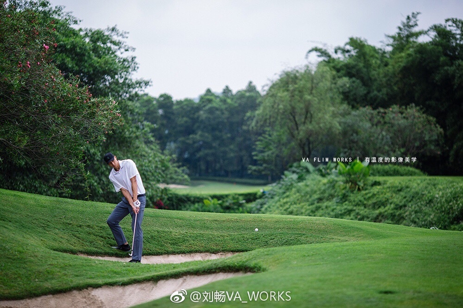 帅气阿联手扶球帽眺望远方，背景是开阔的果岭，举手投足间散发着自信与成熟的魅力