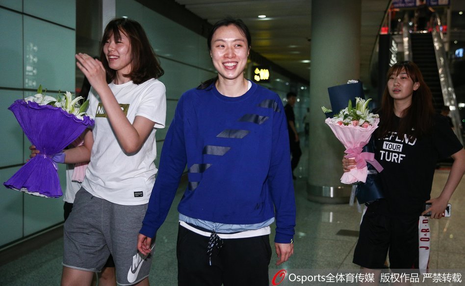 好友在机场大厅热情迎接邵婷，两人相拥而笑，场面温馨动人