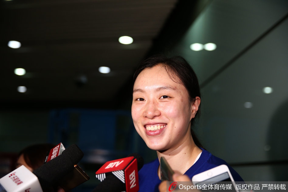 邵婷手持鲜花走在机场通道上，背影充满力量，开启回国后的新征程