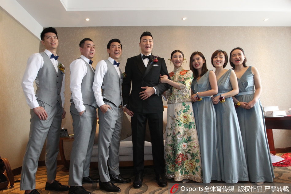 新娘端坐在化妆镜前,化妆师正为她描画眉眼,温柔的光线映照着她嘴角那抹藏不住的幸福微笑,仿佛全世界都在为这一刻绽放。