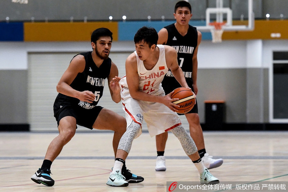 崔晋铭与刘晓宇在三分线外并肩组成防守阵线,两人脚步移动迅速,手臂张开形成屏障,正对新西兰队的持球人实施压迫性的包夹防守。