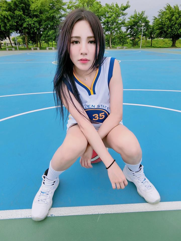 身穿緊身勇士T恤的心心兒，專注地看著遠方，微風吹亂了她的髮絲，卻吹不散她對籃球的熱愛。