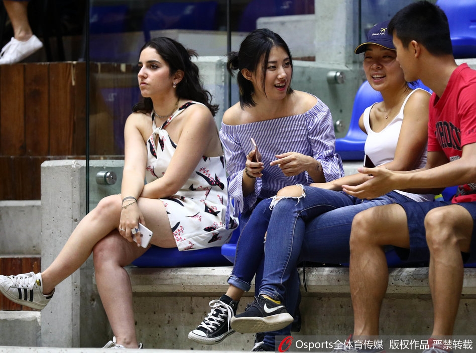 几位球迷在场边热烈交谈,分析着比赛形势,手势丰富,神情投入