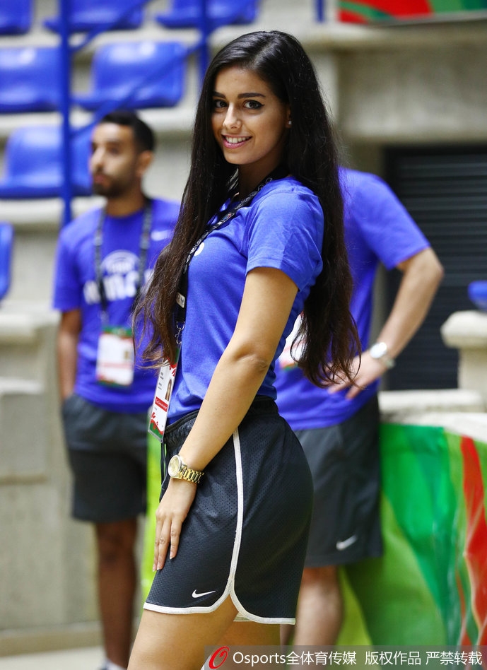 美女球迷举起手机自拍,脸上洋溢着灿烂的笑容,背景是满场的五星红旗