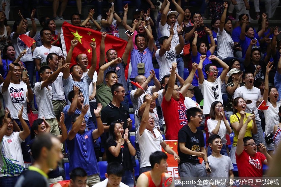 一位可爱的小球迷手拿国旗,眼神天真无邪,笑容温暖人心