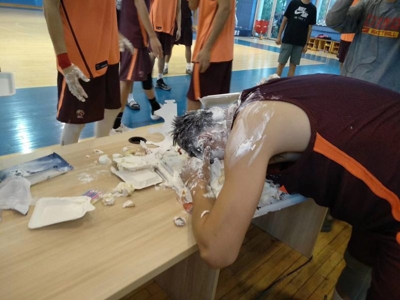 在众人起哄声中,一块蛋糕精准地拍在赵继伟脸上,瞬间奶油飞溅,一旁的周琦探出半个脑袋,咧着嘴偷笑,眼神里满是'恶作剧得逞'的得意。