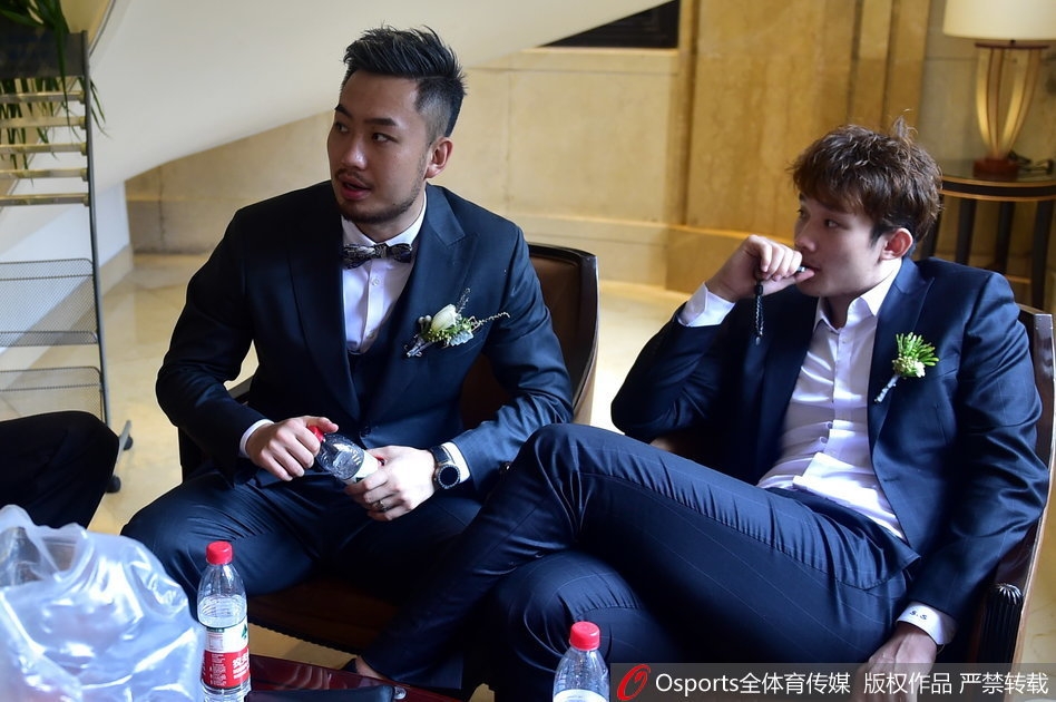 甜蜜定格,新人手捧鲜花在亲友簇拥下合影,画面中每个人脸上都洋溢着笑容