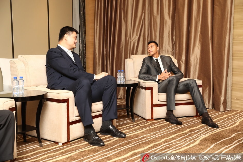 近景镜头中，易建联与姚明面带微笑专注交谈，仿佛在交流着对中国篮球未来的共同期许与信念。