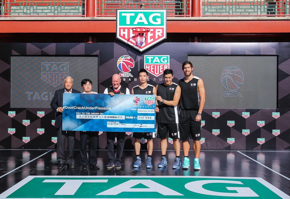 姚明与泰格豪雅首席执行官让-克劳德·比弗在签约台上双手紧握，背景是巨大的签约板，两人脸上洋溢着合作共赢的喜悦，象征着彼此信任的重新建立。