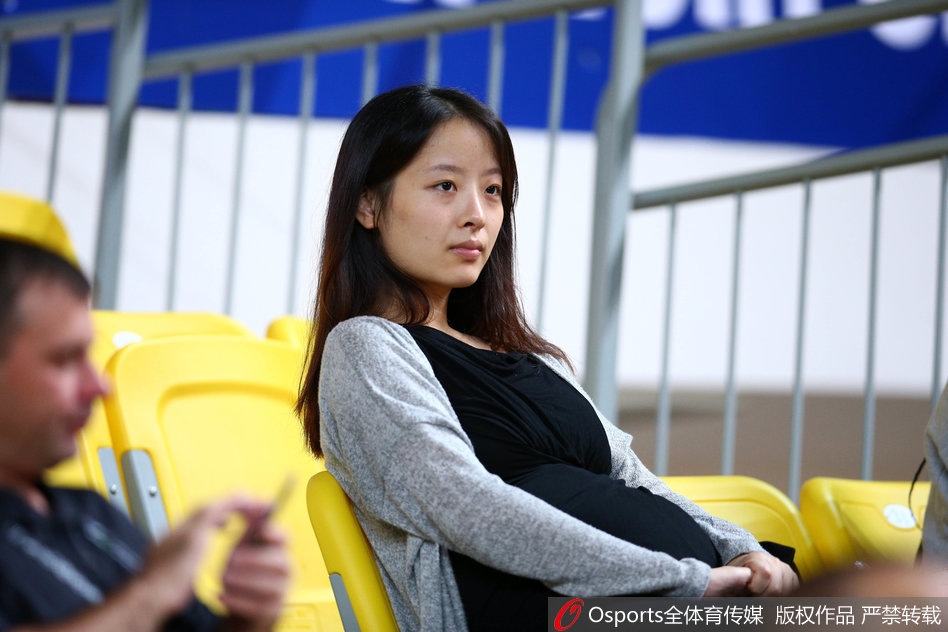 妻子在场边静静凝视,背景是喧嚣的球场和模糊的记分牌,这一刻仿佛世界都安静了,只剩下她眼中那个在场上奔跑的55号身影。