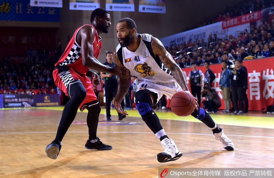 陕西队外援吉伦沃特面对安徽文一男篮著名中锋詹姆斯的贴身防守，毫无畏惧地强行突破上篮，身体在空中舒展开来，篮球应声入网。