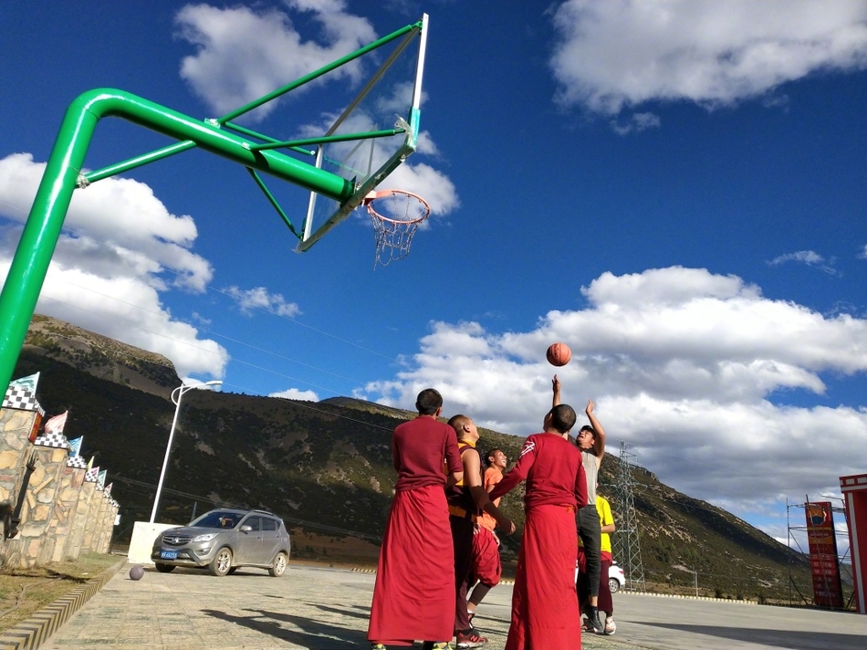 球场上,两名喇嘛正激烈地争抢篮板,僧袍的宽大袖口随风扬起,露出他们结实的手臂。他们的眼神紧盯着篮球,那股认真劲儿丝毫不亚于专业运动员。